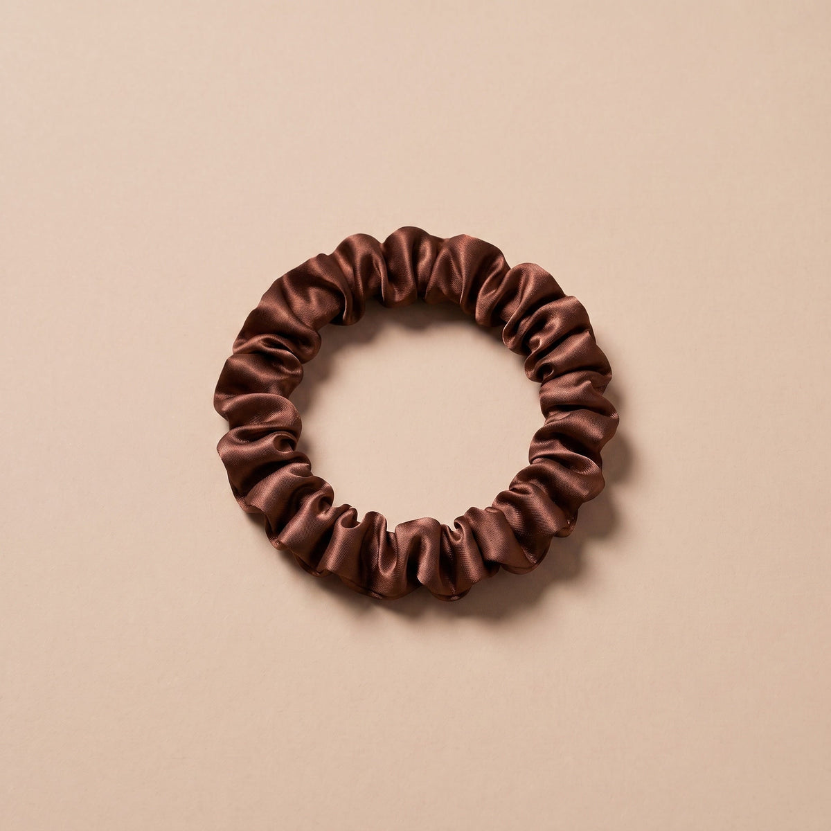 Cienka gumka scrunchie czekoladowy braz na bezowym tle