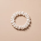 Cienka gumka scrunchie sniezna biel na bezowym tle
